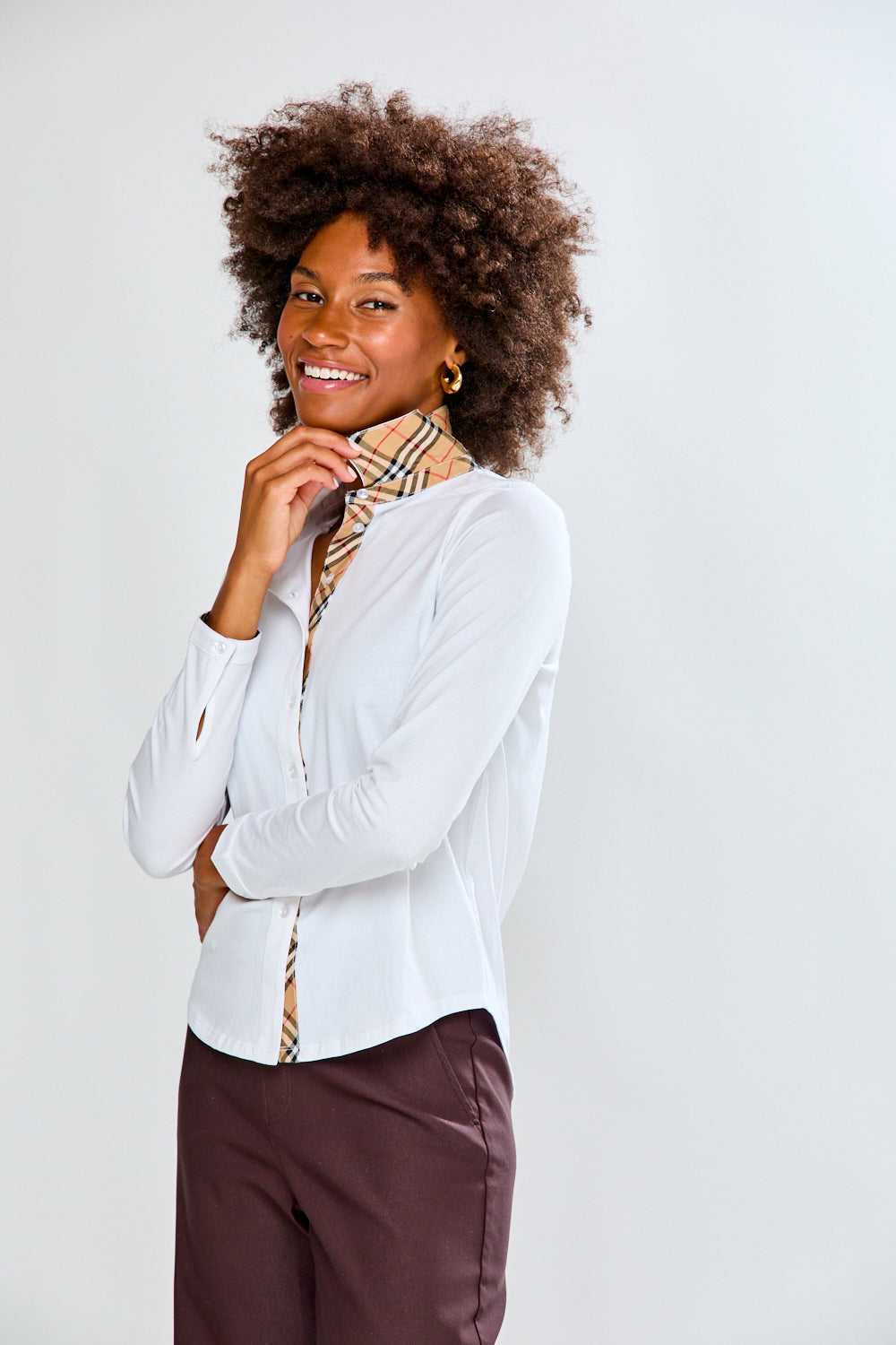 Woman wearing a white shirt and brown pants on a white background