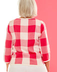 Woman in pink gingham sweater