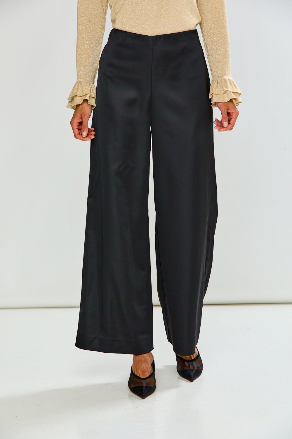 The Reyna Pant - Black wide-leg women's pants styled with a cream blouse and pointed toe heels for a sophisticated timeless look