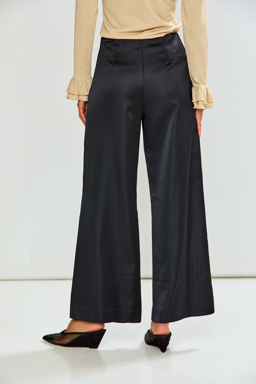 The Reyna Pant - Black shown as sophisticated wide leg women's pants styled with a neutral top and black heels