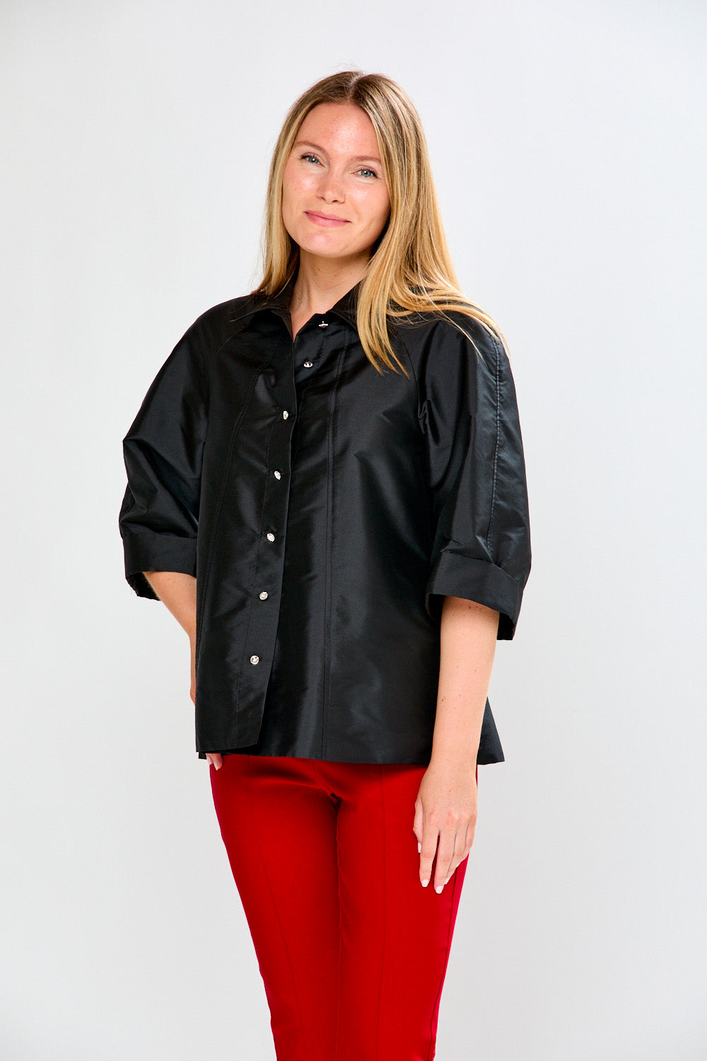 Woman wearing a black shirt and red pants on a white background