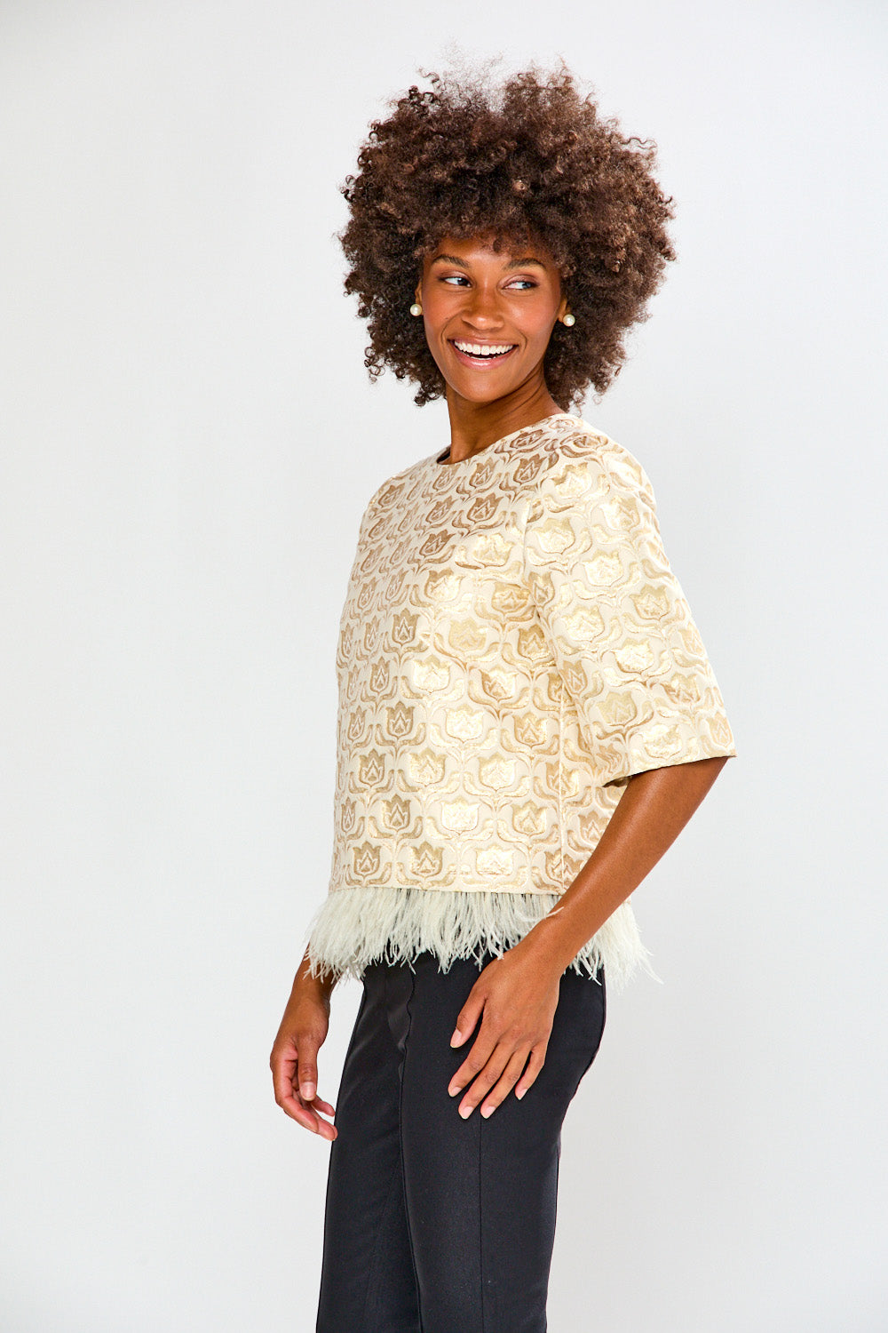 Woman wearing a beige lace top against a white background