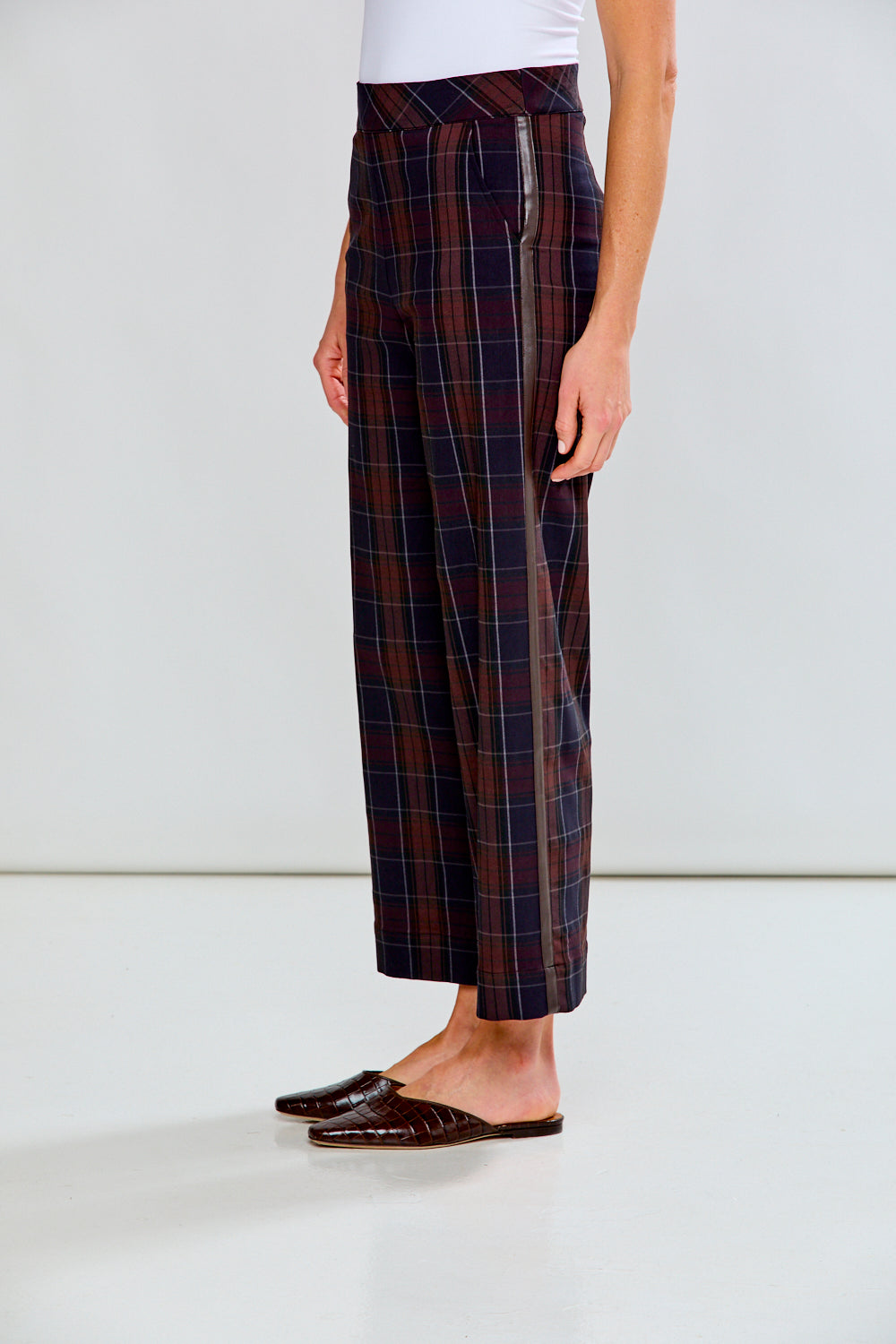 Person wearing plaid pants with a white background