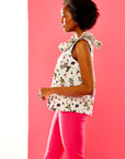 Woman in berry print blouse and pink pants