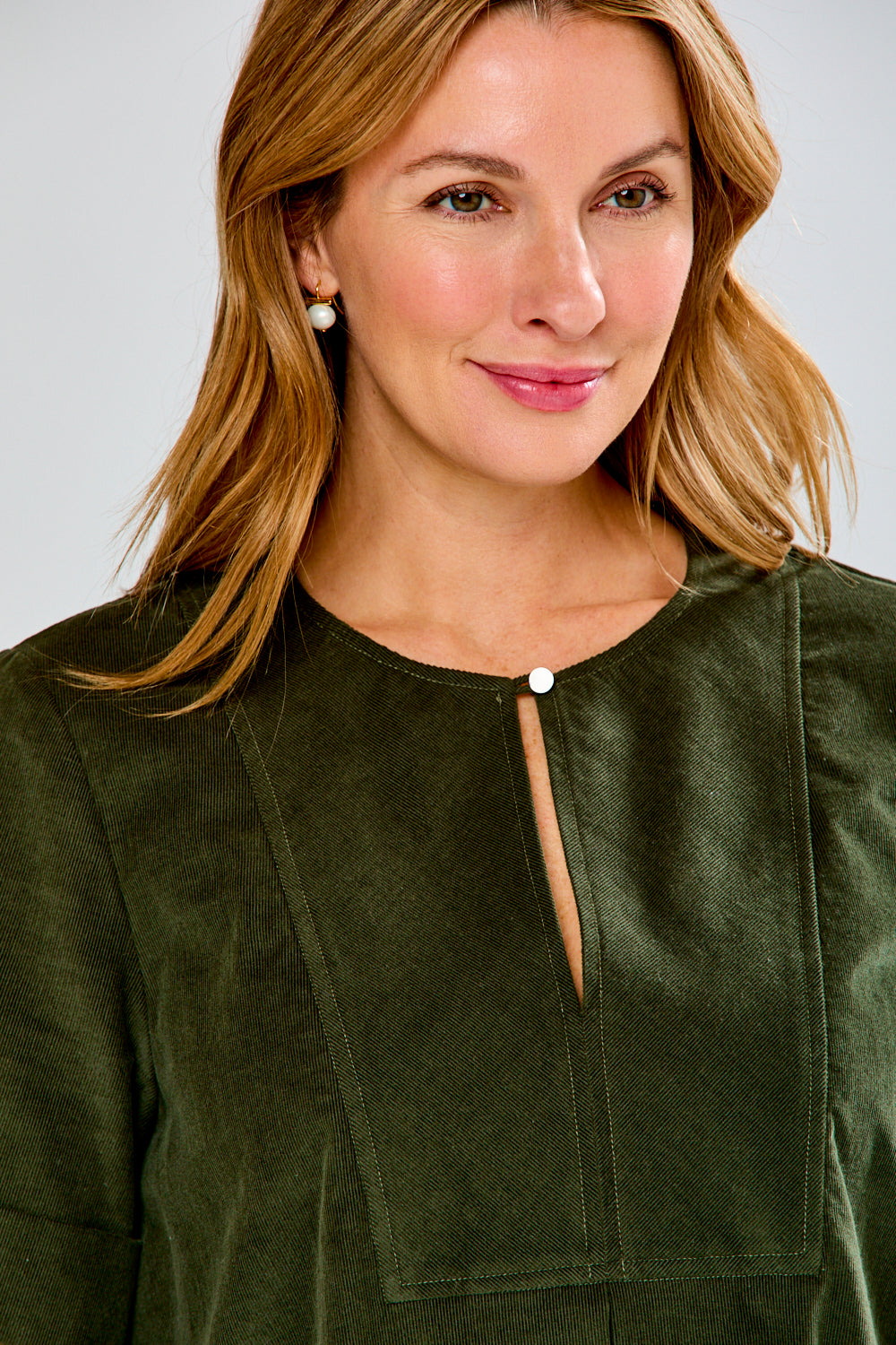Woman wearing a green dress against a white background