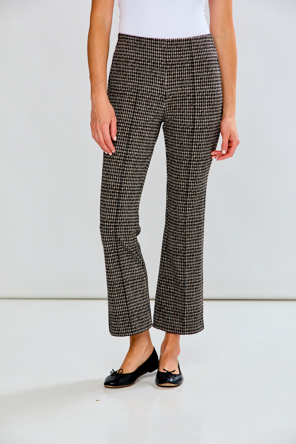 Person wearing houndstooth patterned pants on a plain background
