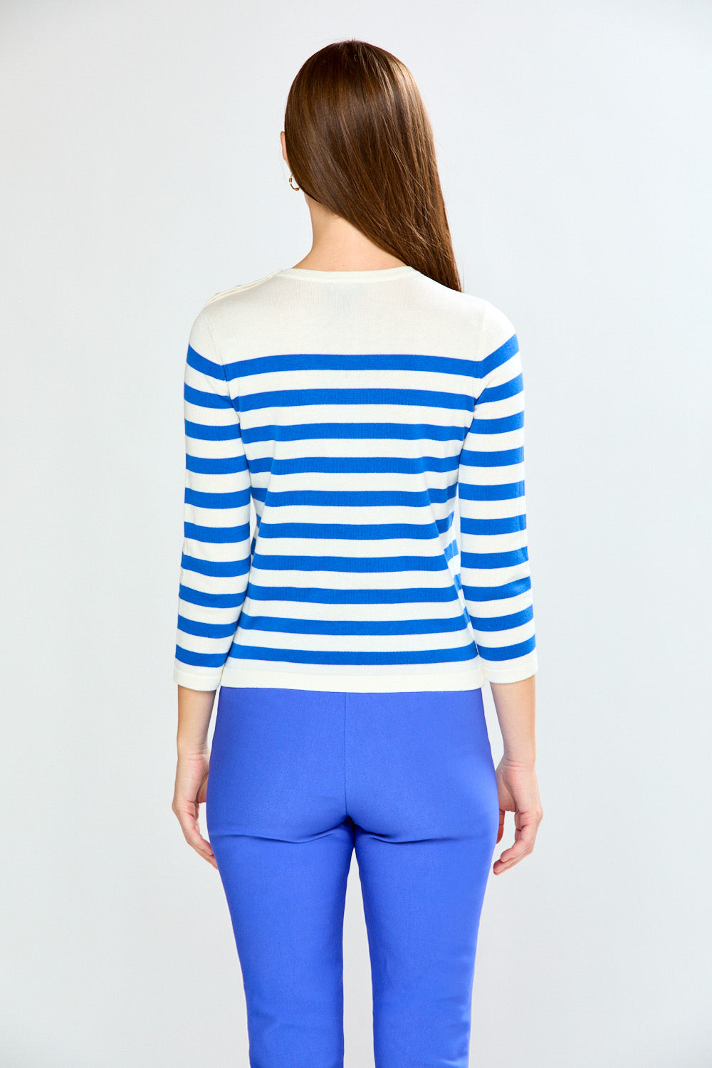 Person wearing a blue and white striped sweater and blue pants on a white background