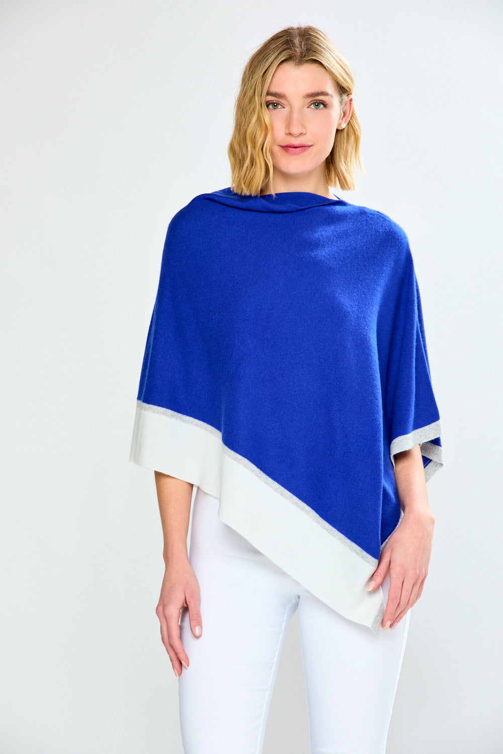 Woman wearing a blue and white poncho against a white background