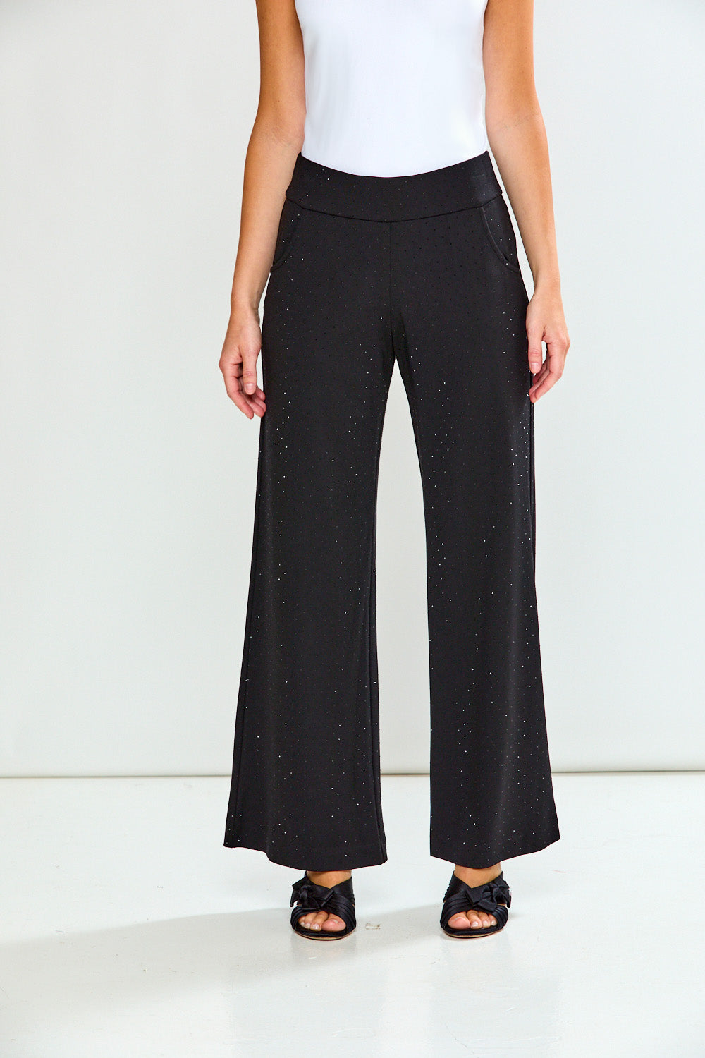 Black wide-leg pants worn by a person on a white background