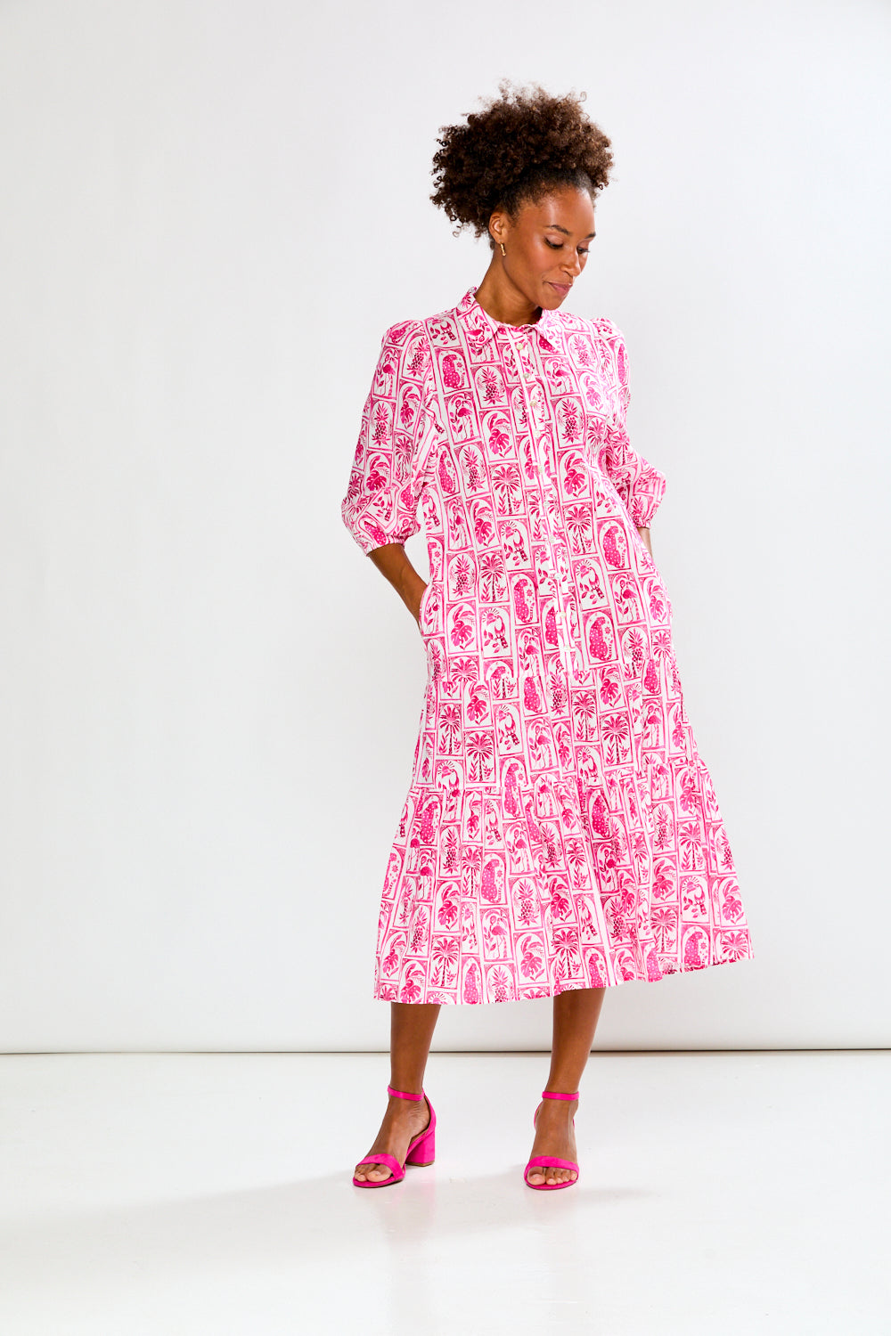 Woman wearing a pink and white patterned dress on a white background