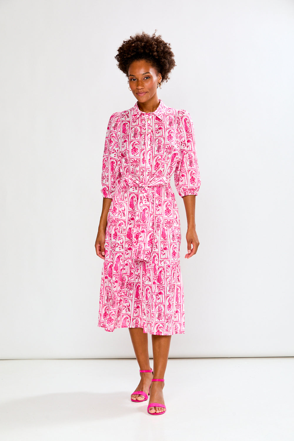 Woman wearing a pink and white patterned dress on a white background