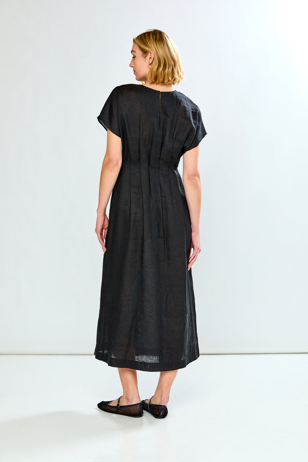 Woman wearing a black dress against a white background