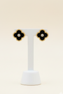 Photo of a par of black clover studs on an earring stand