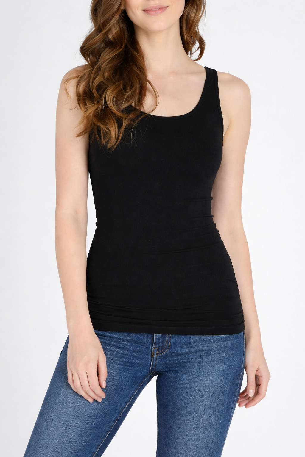 Woman wearing a black tank top and blue jeans on a white background