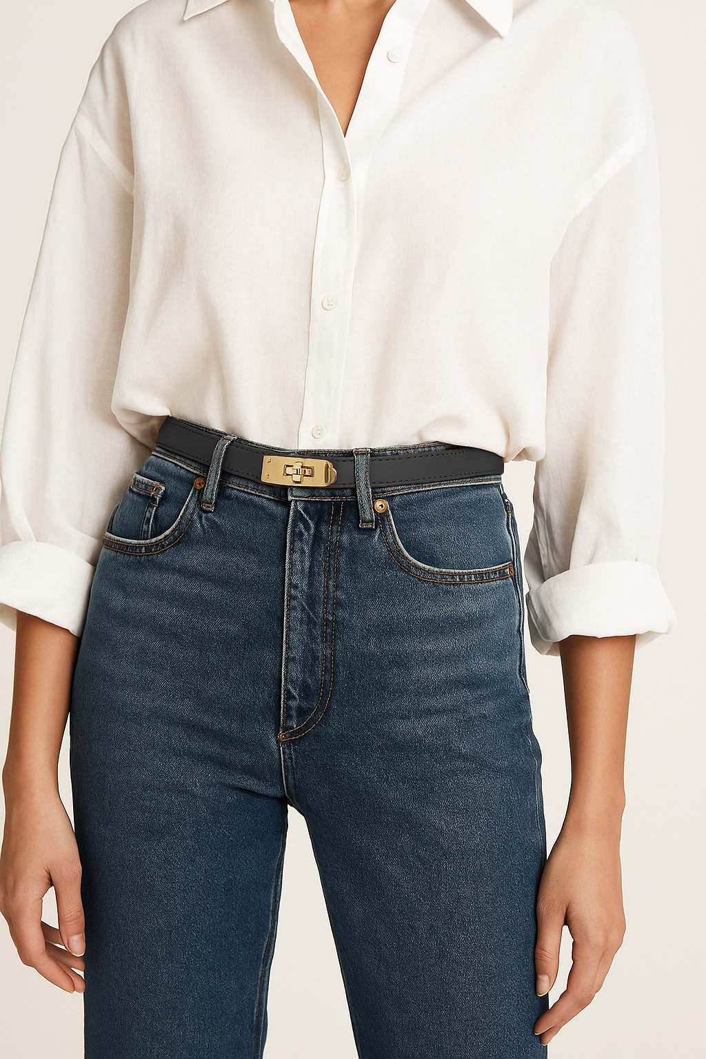 Person wearing a white shirt and blue jeans with a beige background