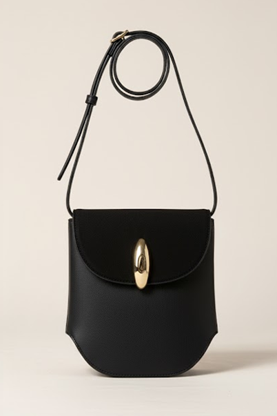 Black handbag with a gold clasp on a beige background