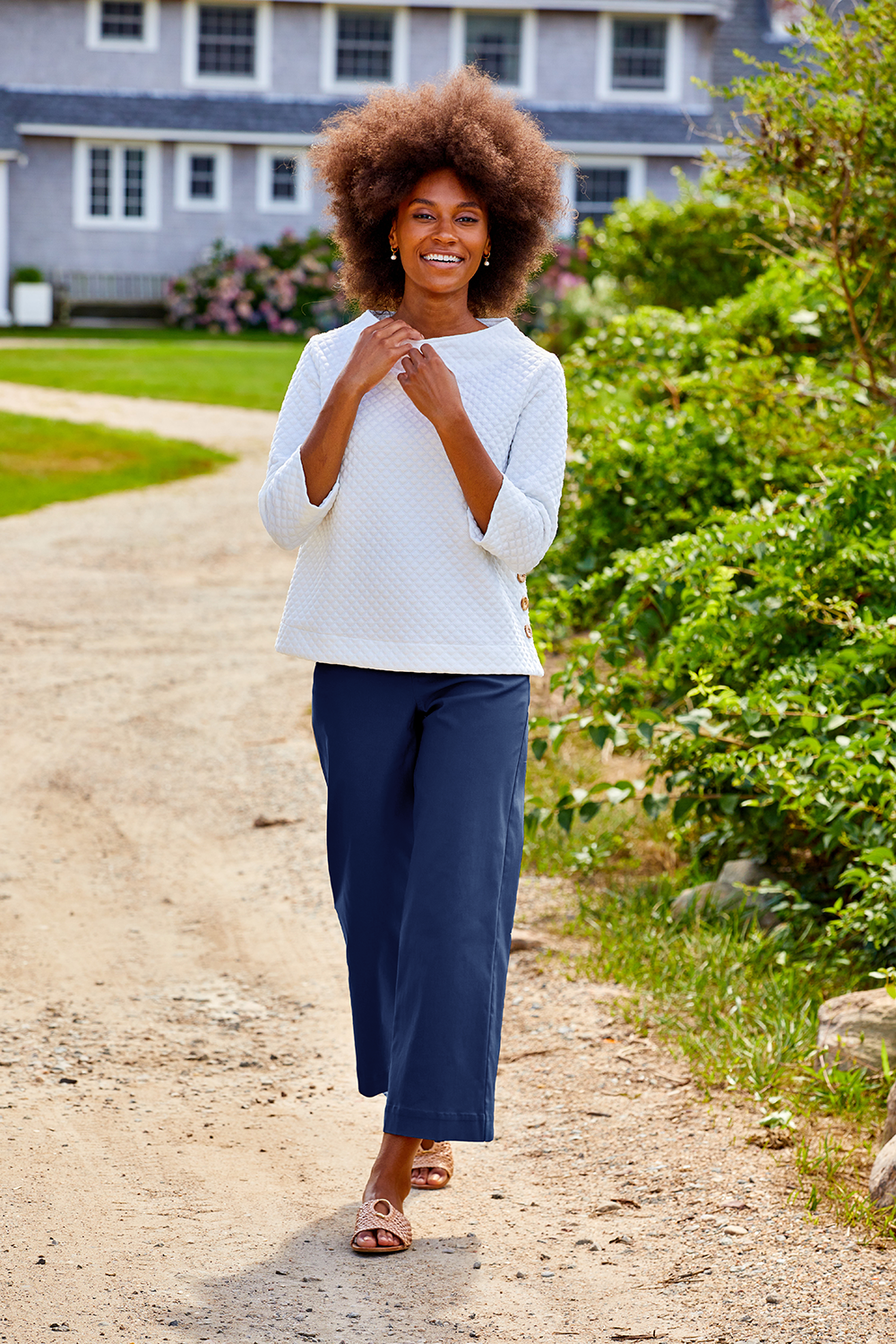 Woman walking wearing navy pants and a sweater