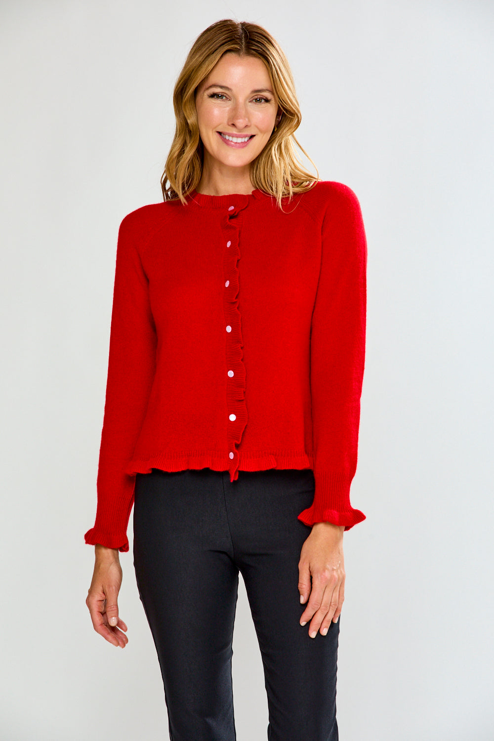 Woman wearing a red cardigan over a black top on a white background