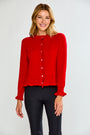 Woman wearing a red cardigan over a black top on a white background