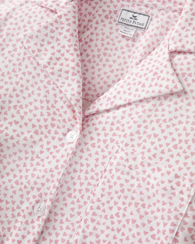 Pink shirt with small pattern and 'Petite Plume' label on a white background