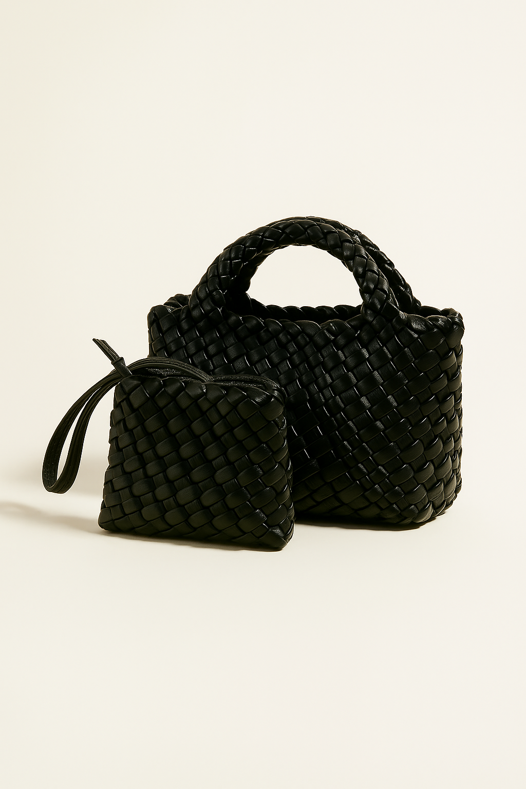 Black woven handbag and pouch on a beige background