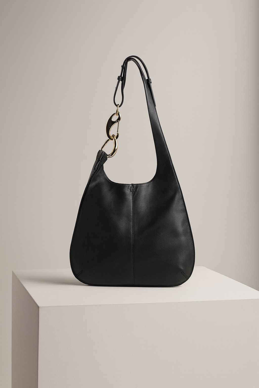 Black handbag with gold chain on a light gray background