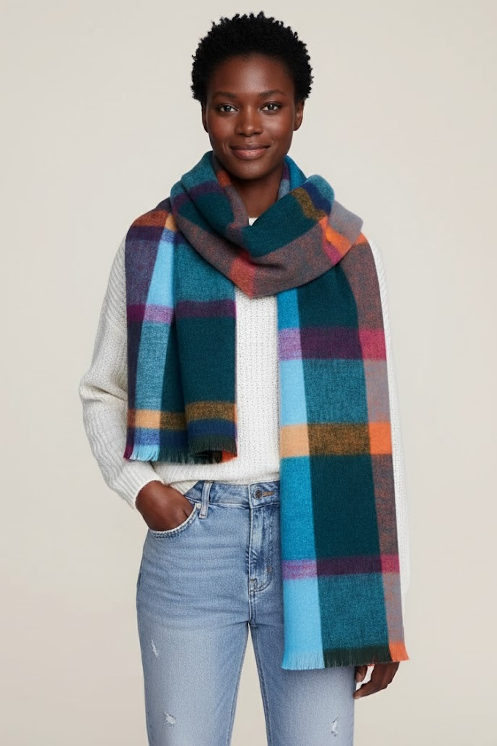 Person wearing a colorful plaid scarf with a plain background