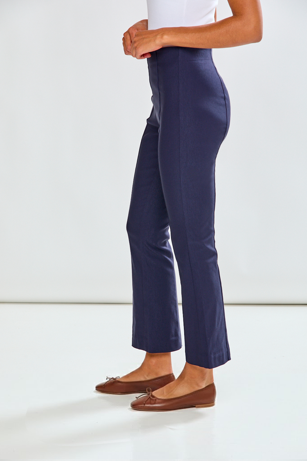 Navy blue pants worn by a person on a white background