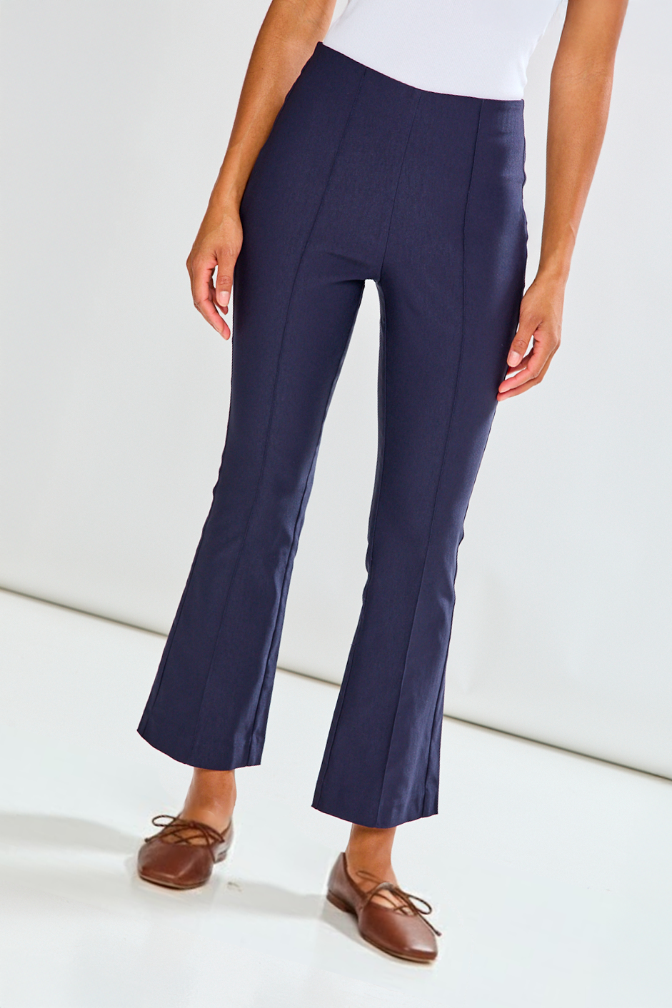 Navy blue pants worn by a person on a white background