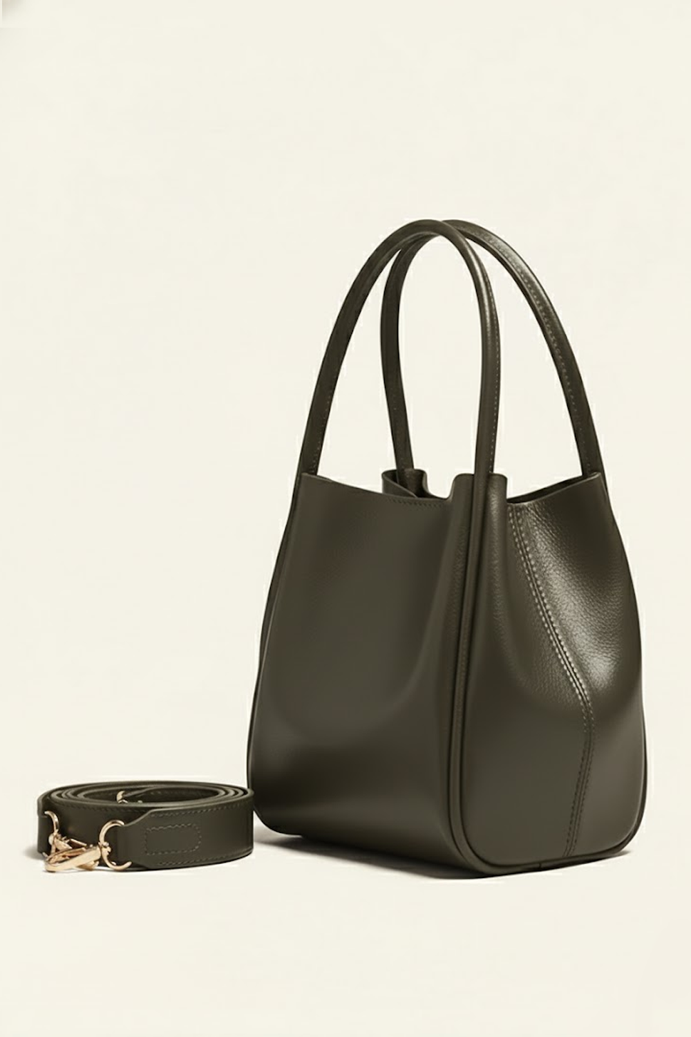 Green handbag with a matching strap on a beige background