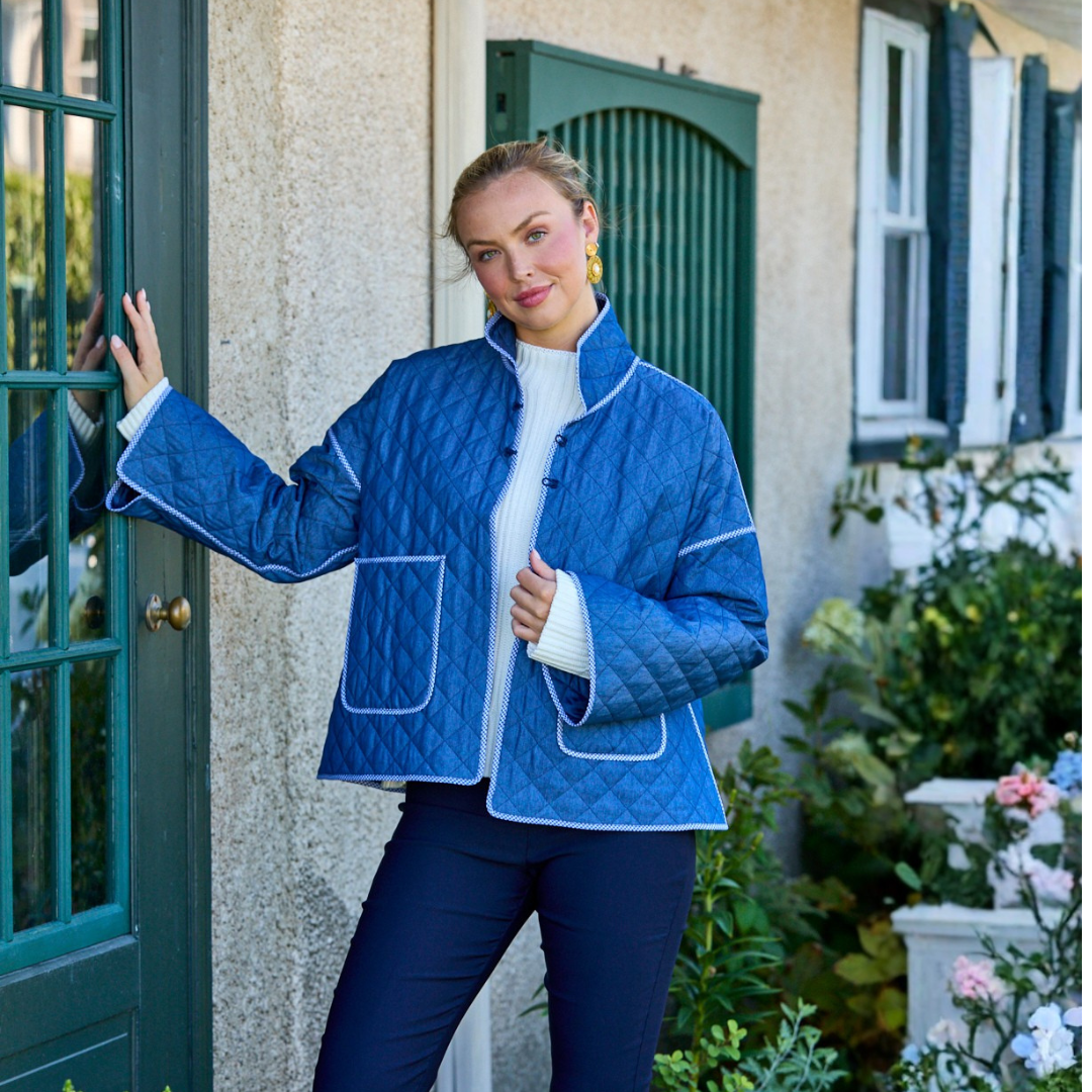 Girl in a jacket posing by a door