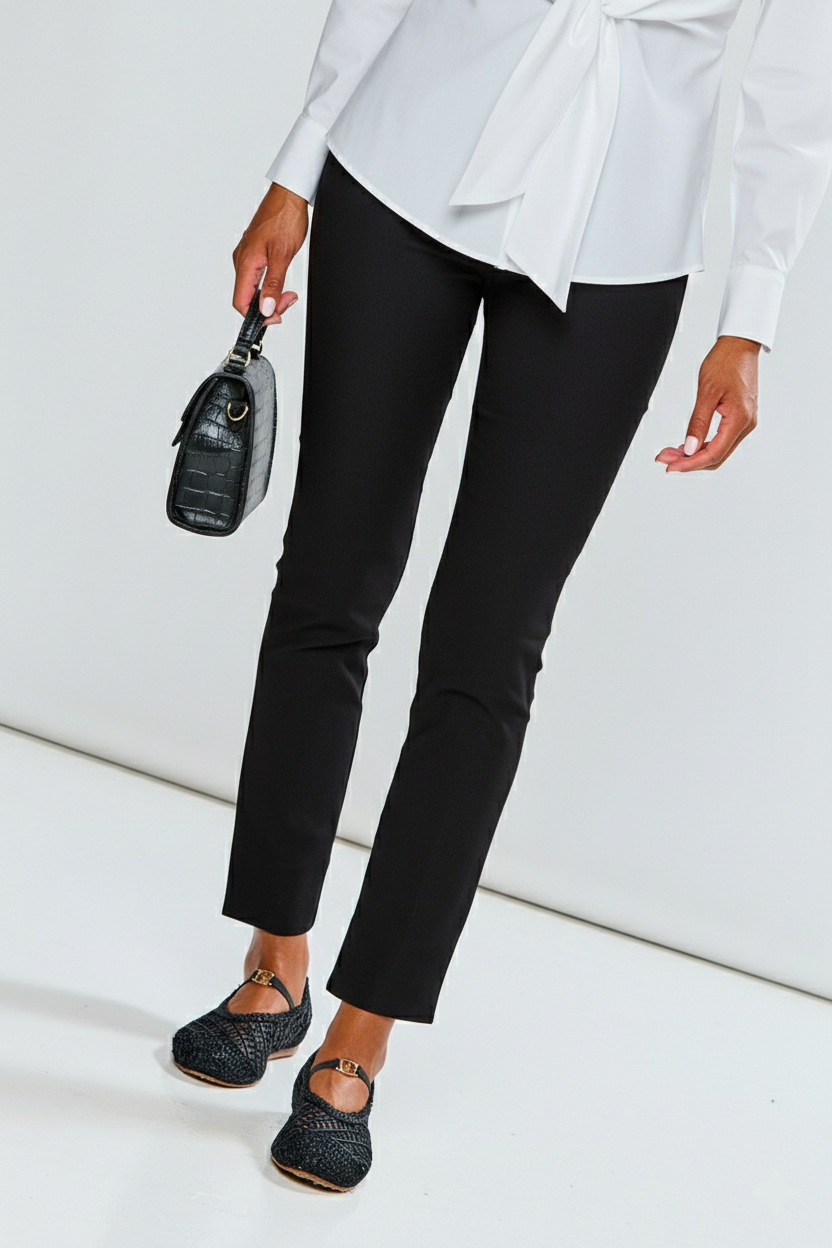Person wearing a white blouse, black pants, and black shoes on a white background