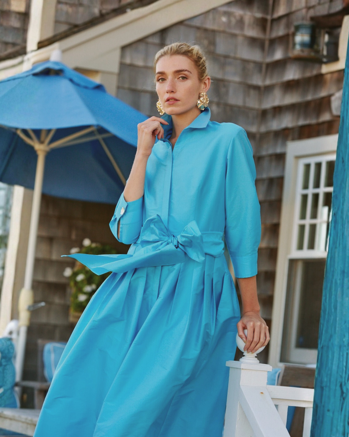 Girl in blue dress standing on porch