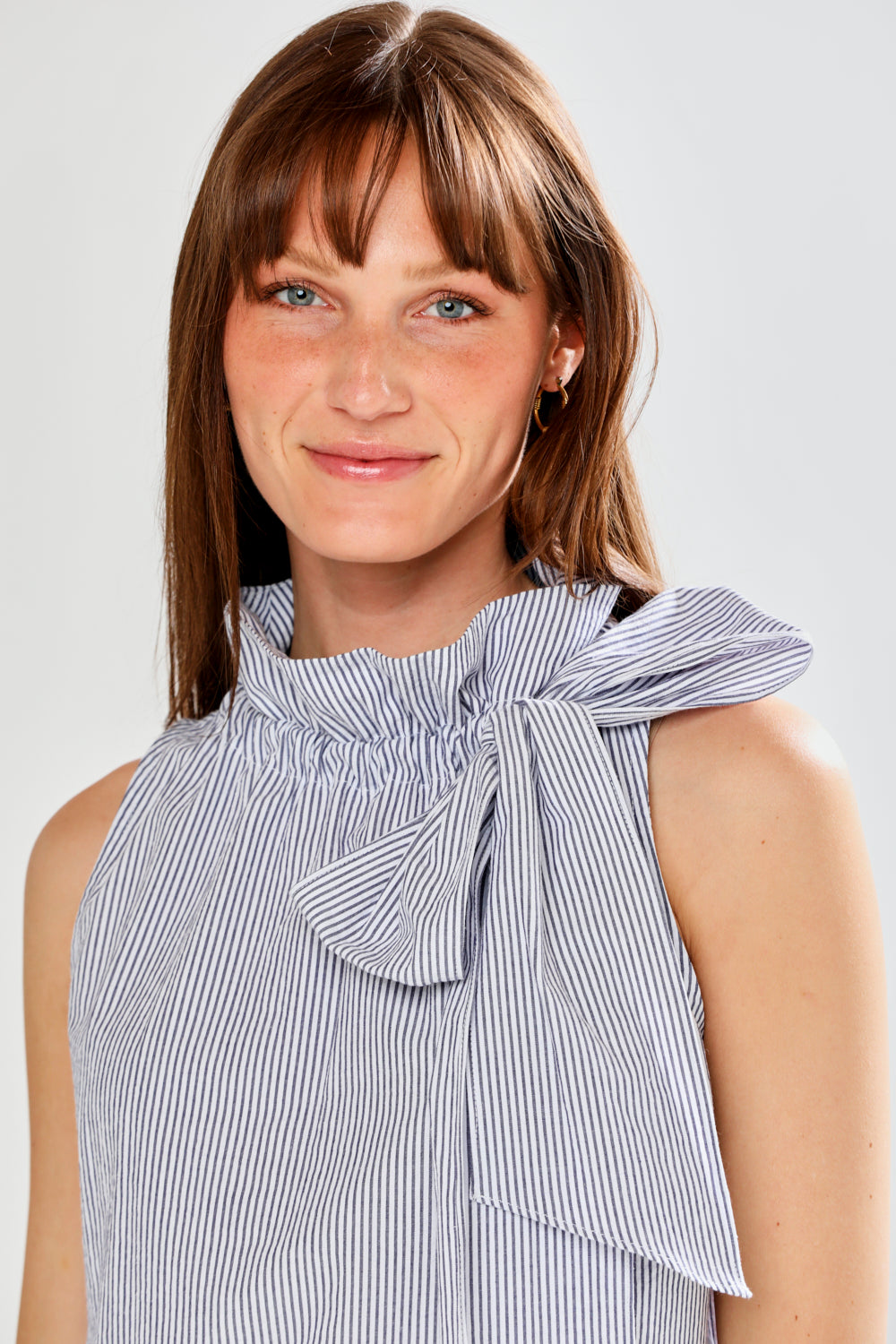 Woman wearing SLEEVELESS TOP W/TIE AT NECK