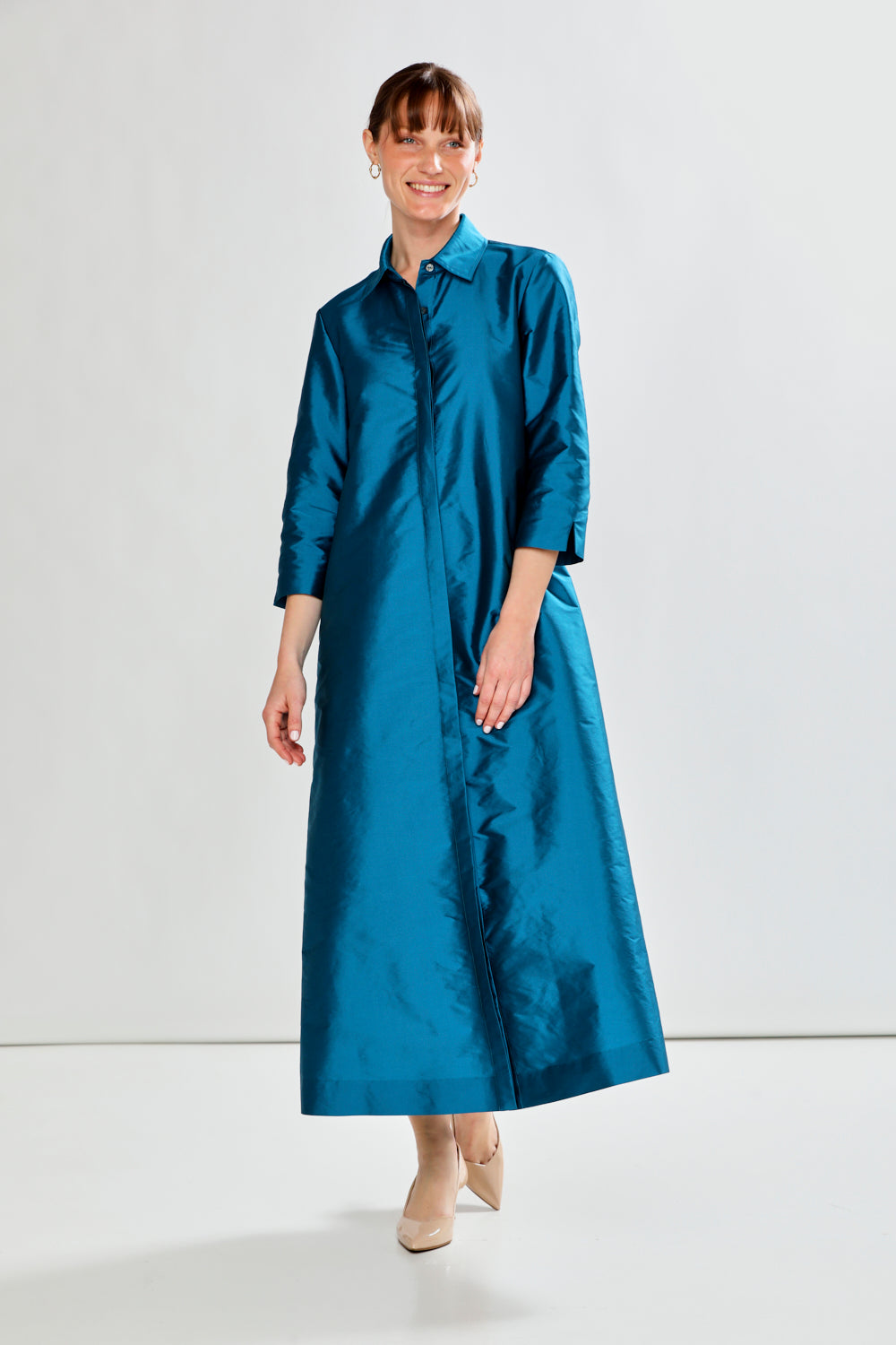 Woman wearing a blue dress against a white background