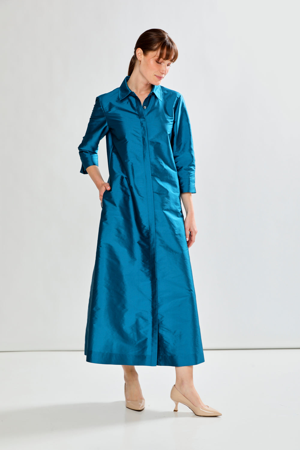 Woman wearing a blue dress against a white background