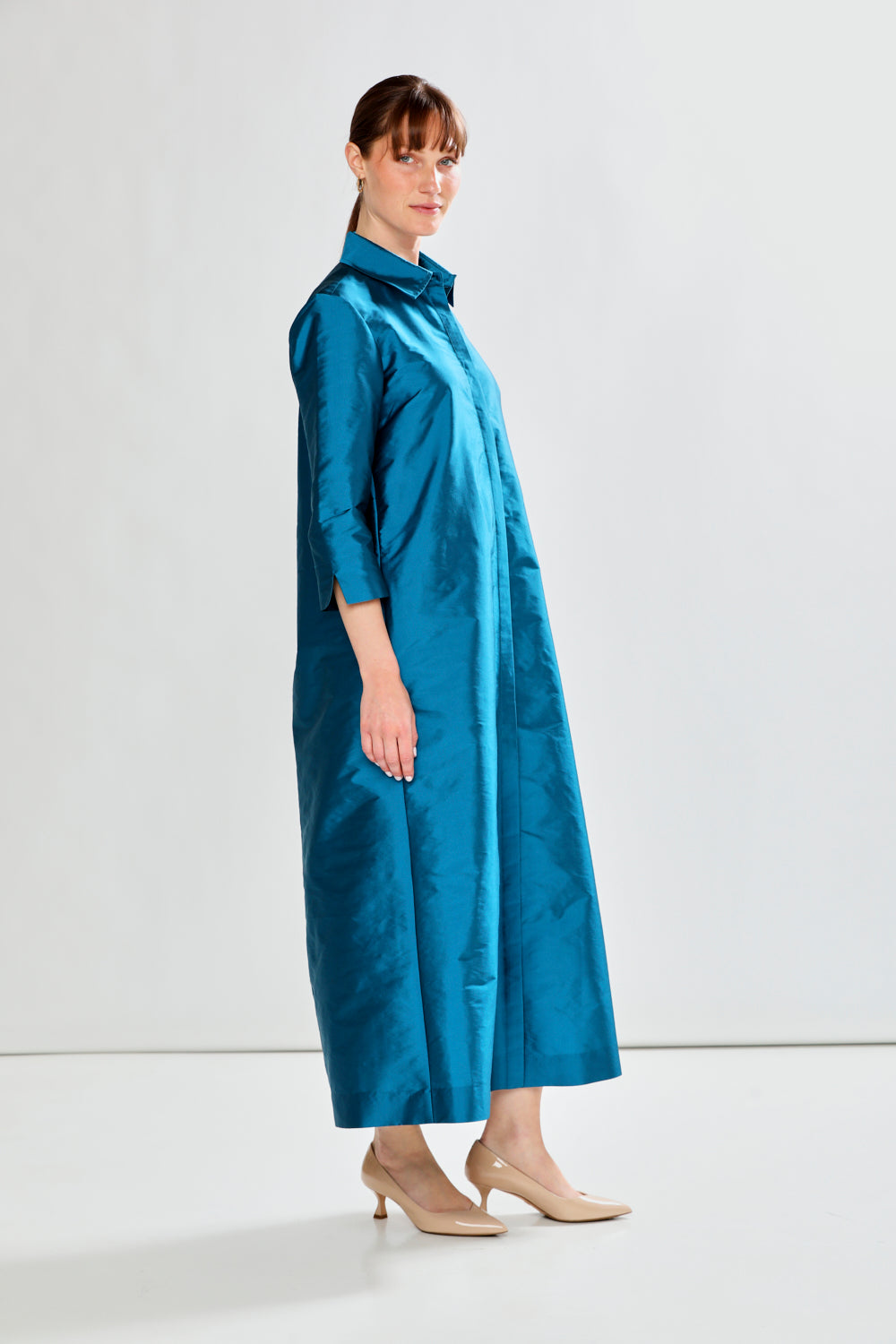 Woman wearing a blue dress against a white background