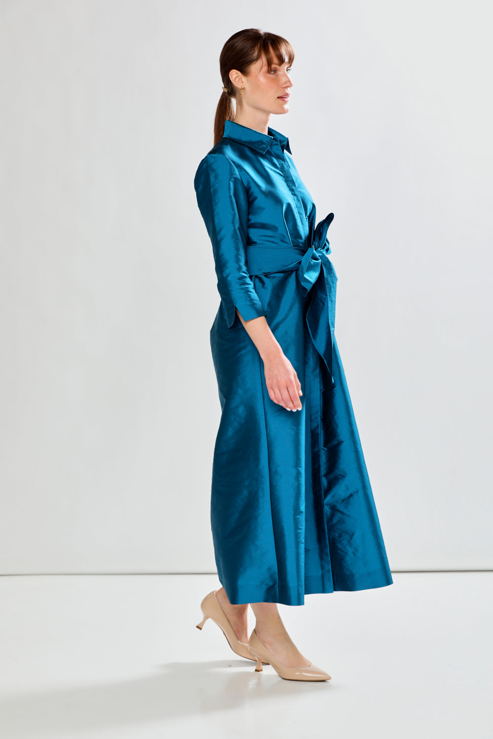 Woman wearing a blue dress with a white background