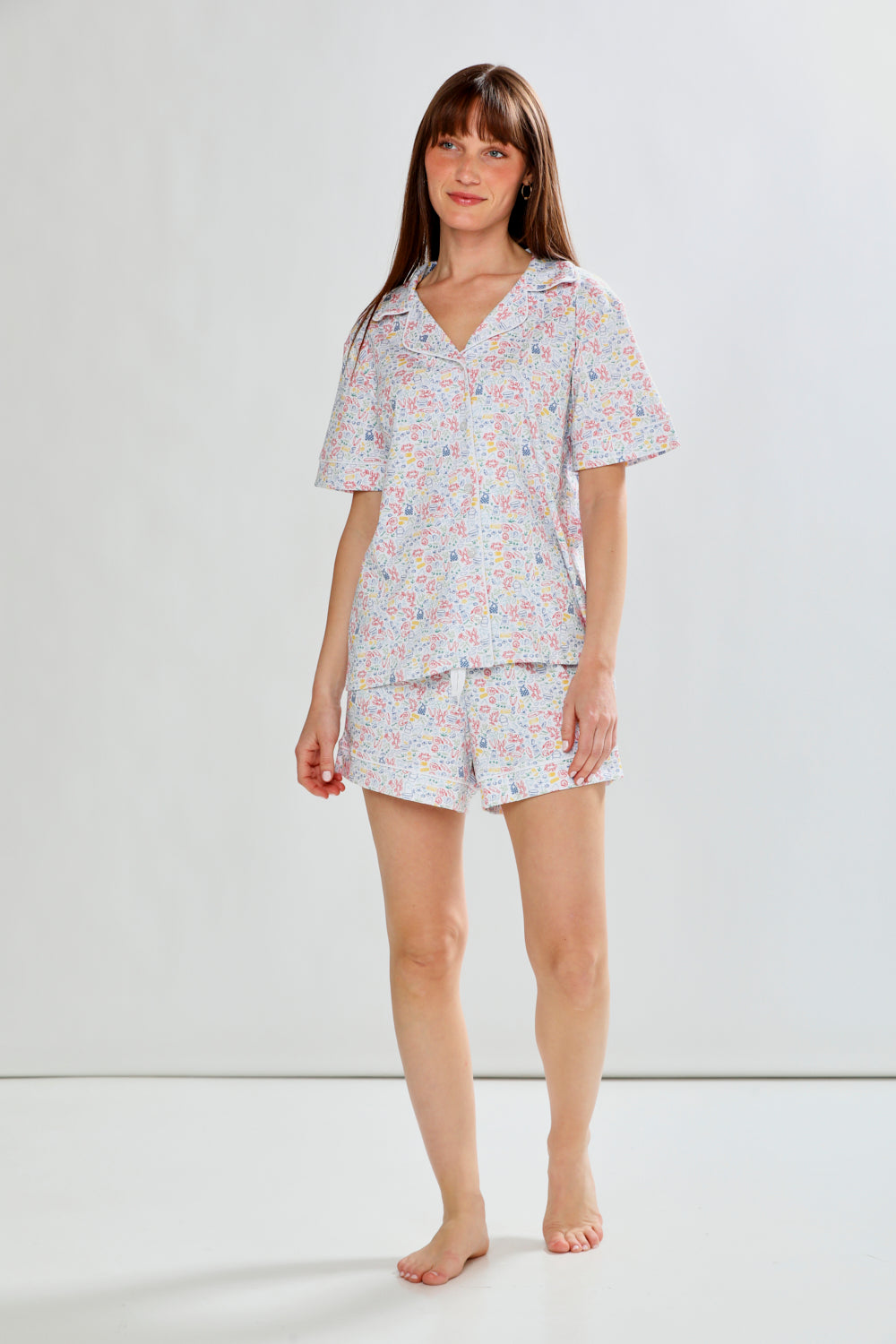 Woman wearing lobster print pajama set on a white background