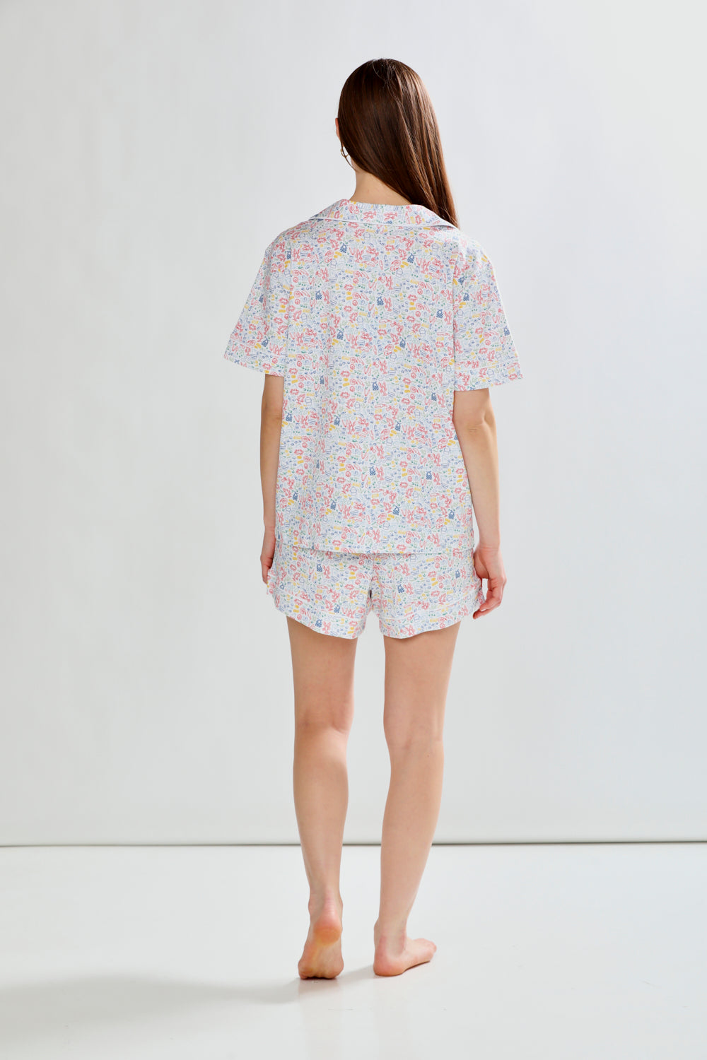 Woman wearing lobster print pajama set on a white background