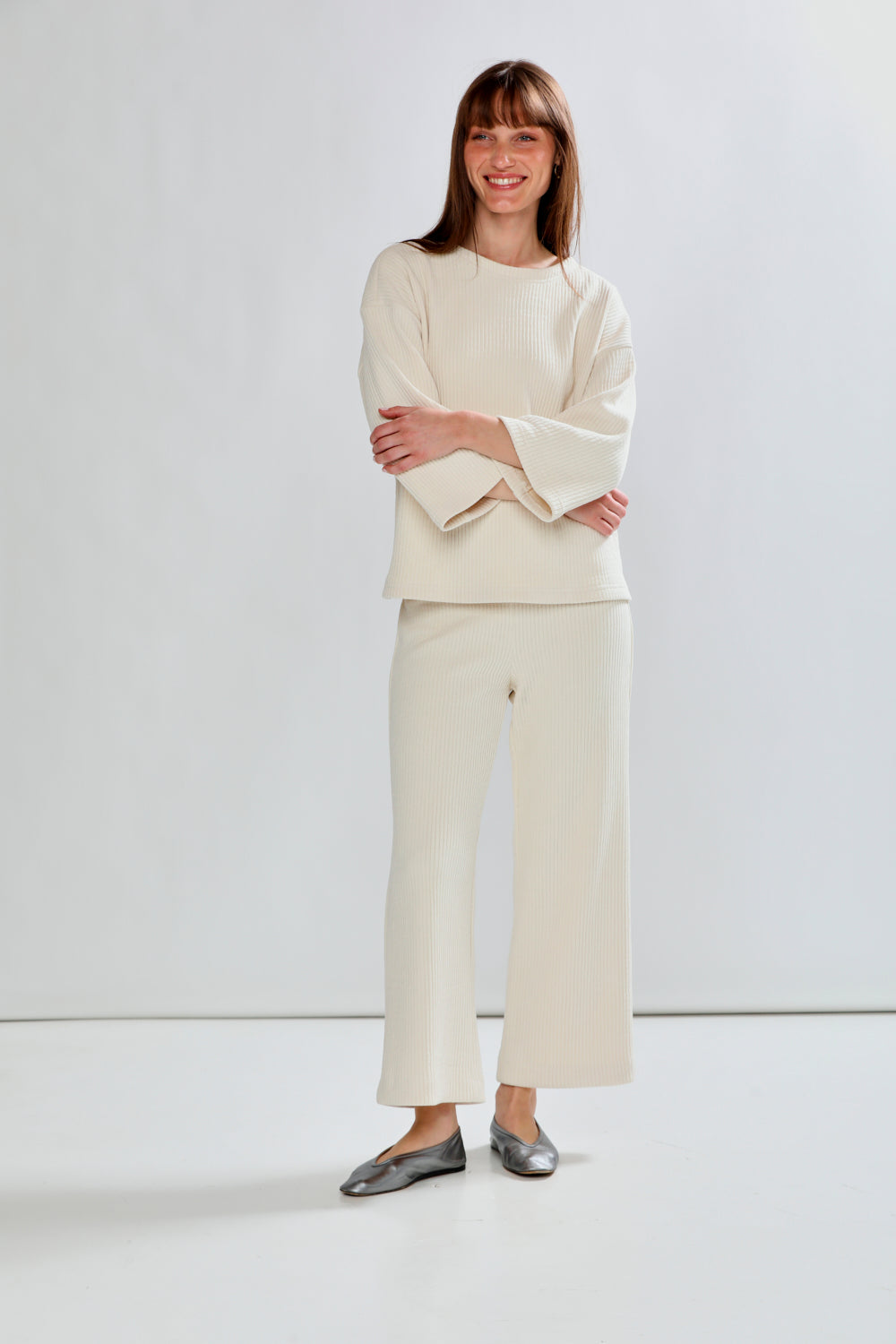 Woman wearing a white outfit with a plain background