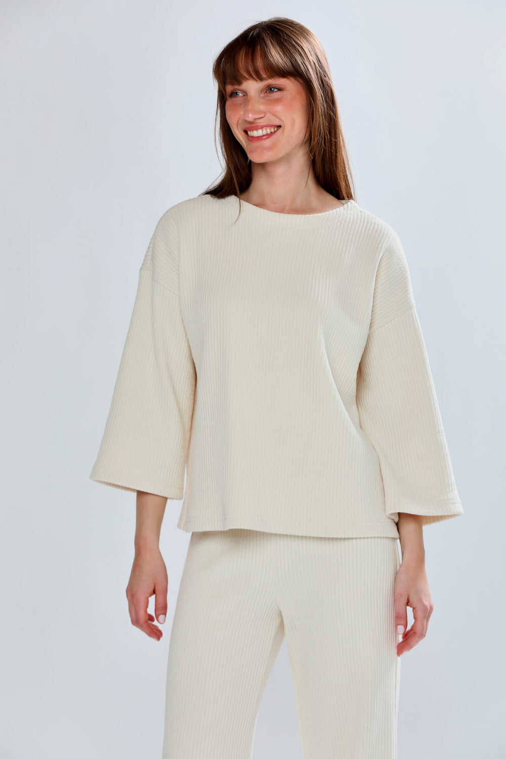 Woman wearing a cream-colored outfit on a white background