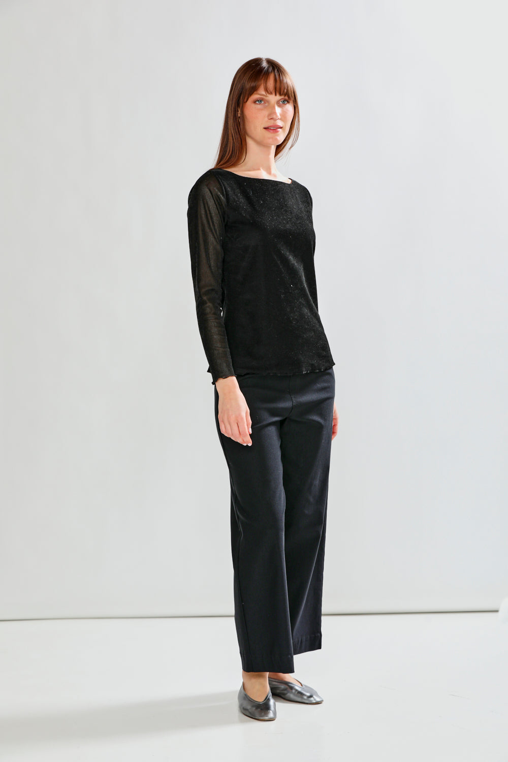 Woman wearing a black outfit against a white background