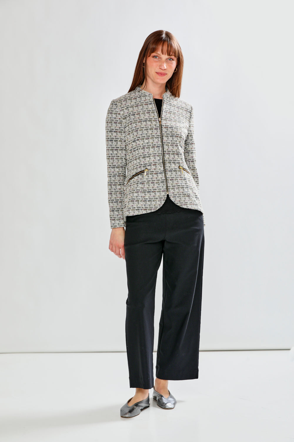 Woman wearing a patterned jacket on a plain background