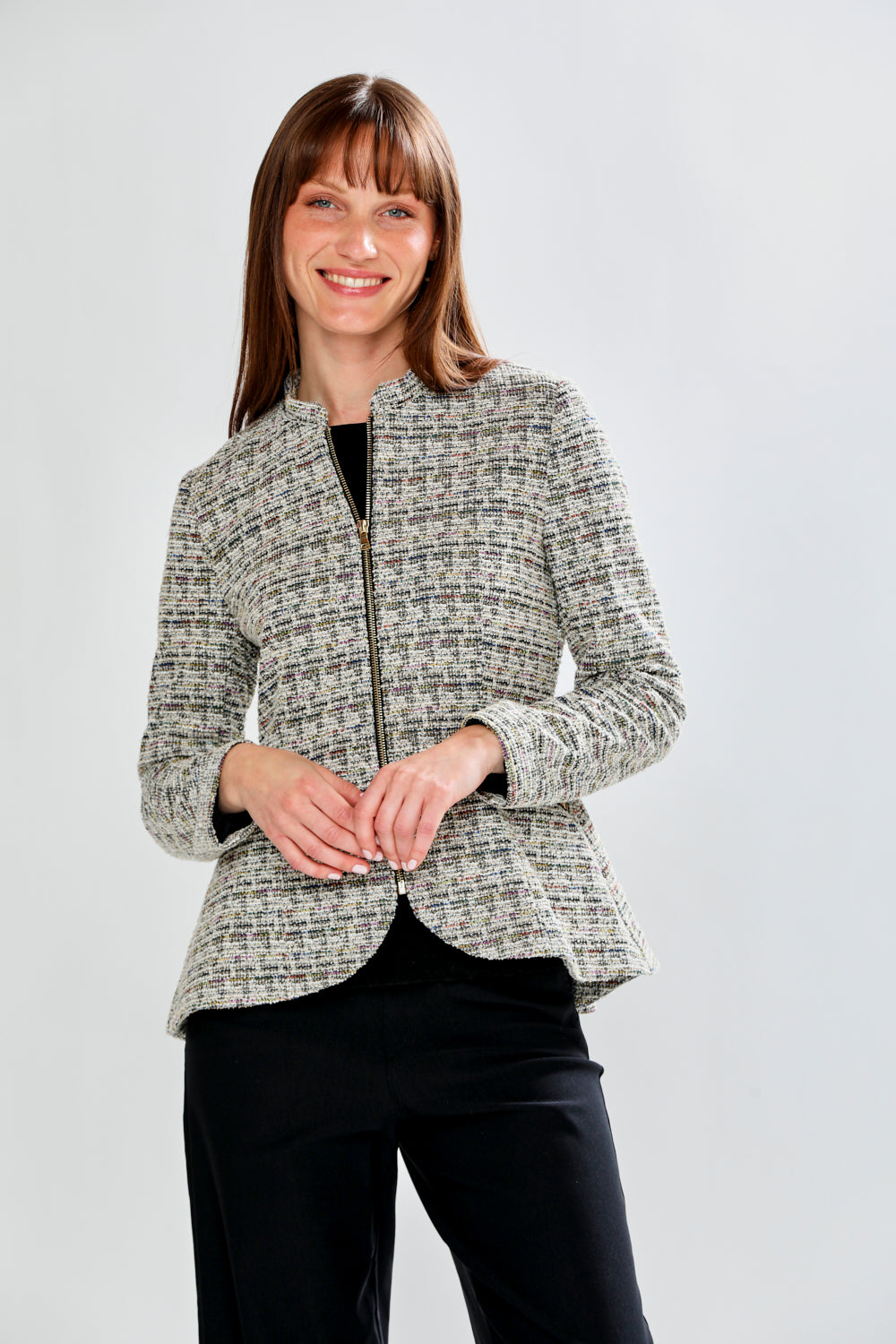 Woman wearing a patterned jacket on a plain background
