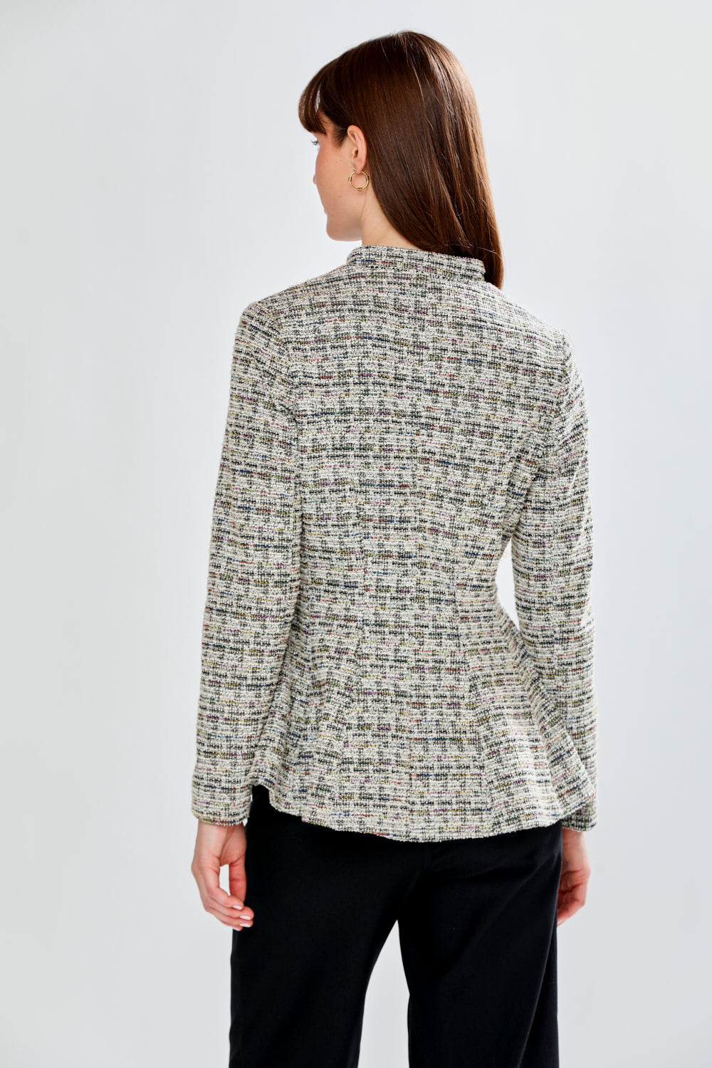 Woman wearing a patterned jacket on a plain background