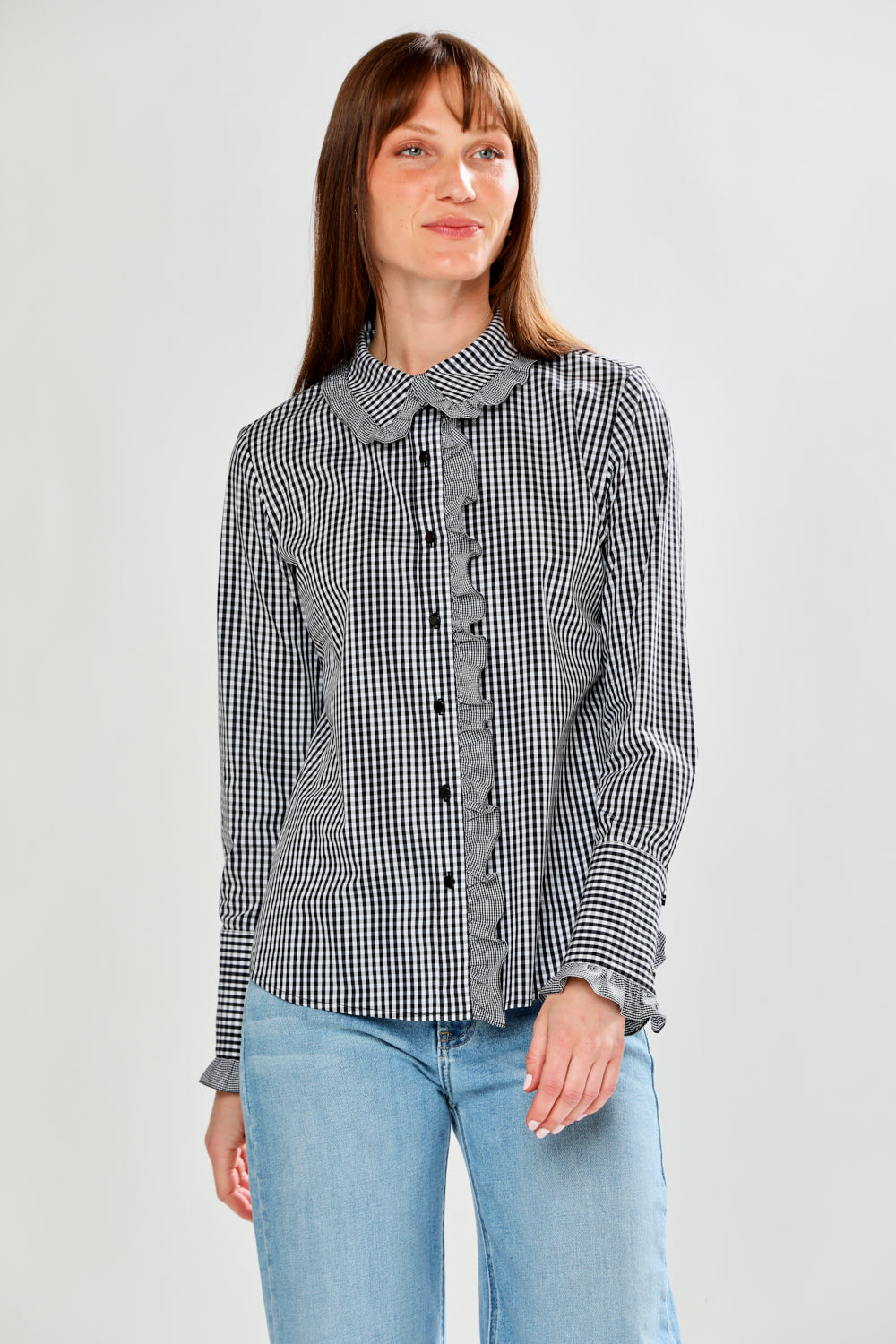 Woman wearing a black and white checkered shirt with a collar on a light gray background