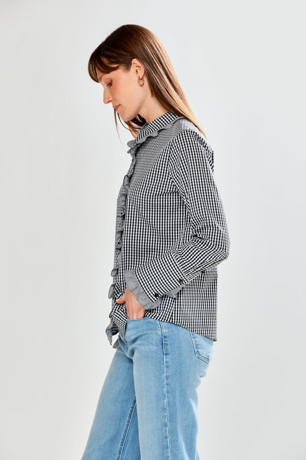 Person wearing a checkered shirt and light blue jeans on a white background