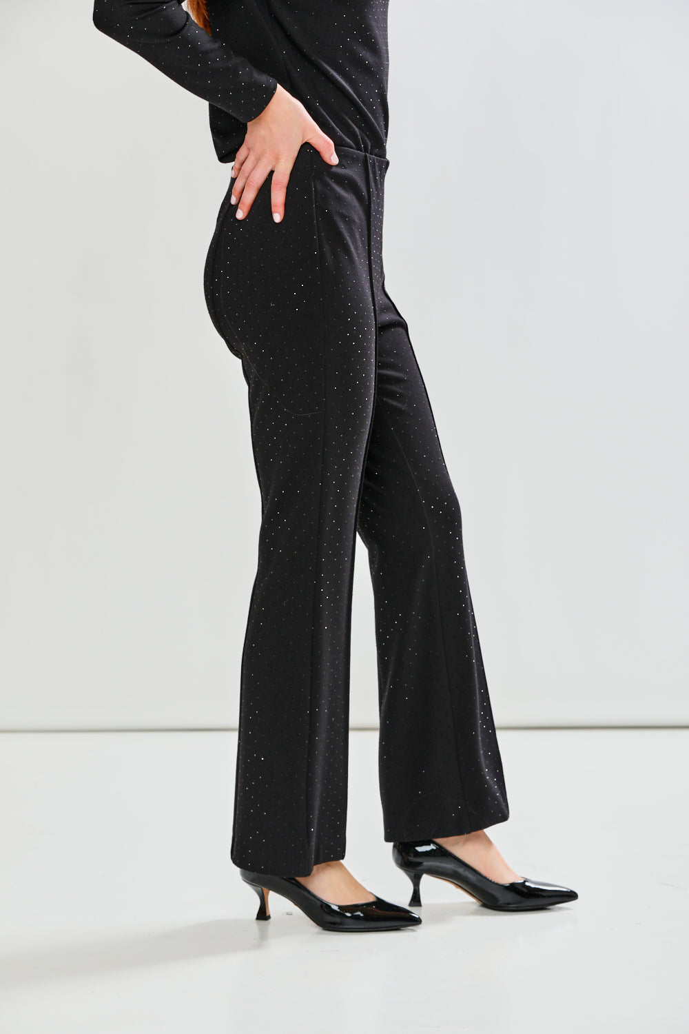 Person wearing black pants and high heels on a white background