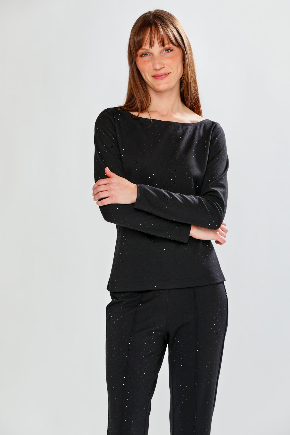 Woman wearing a black outfit with small patterns on a light gray background